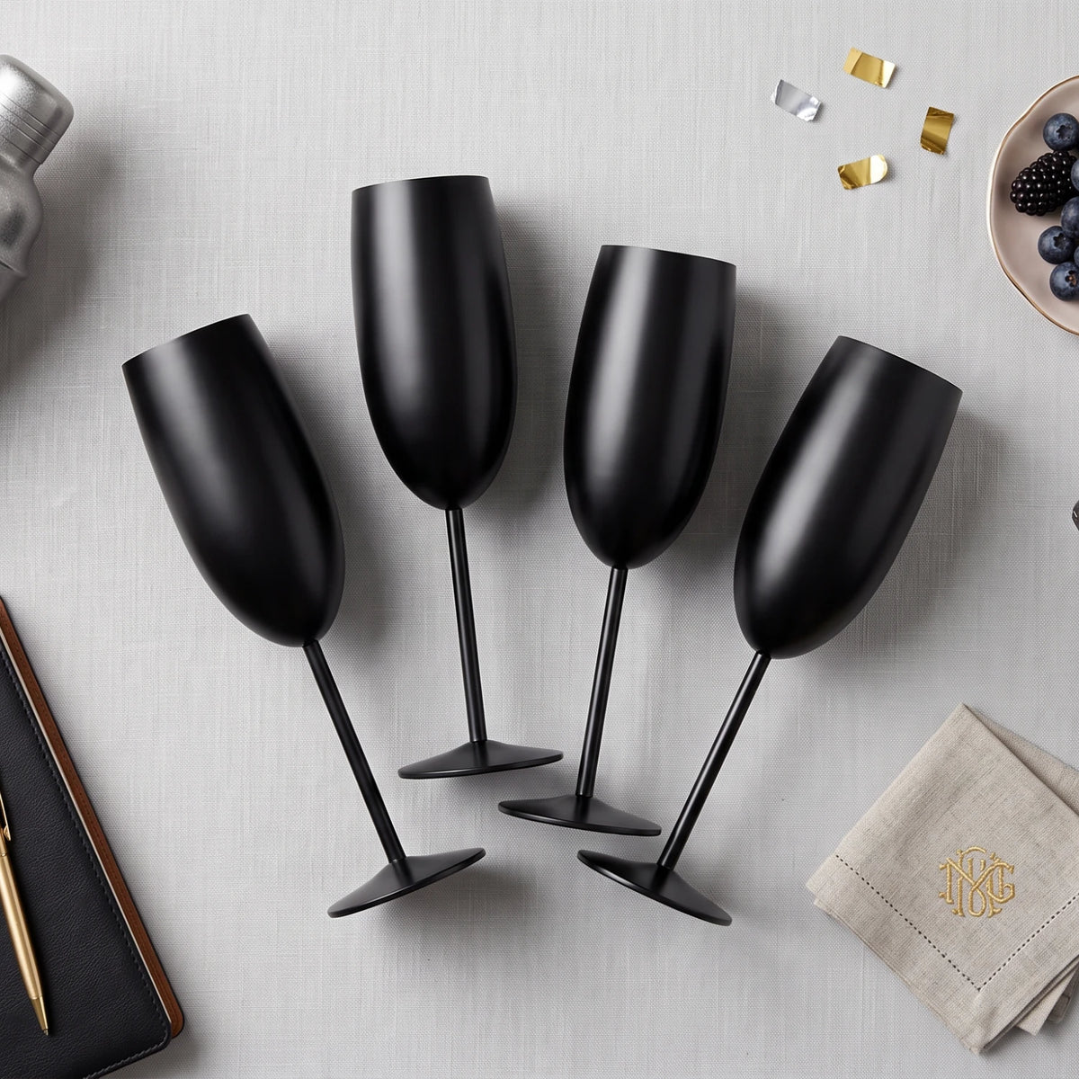 Four matte black champagne flutes with long stems and round bases