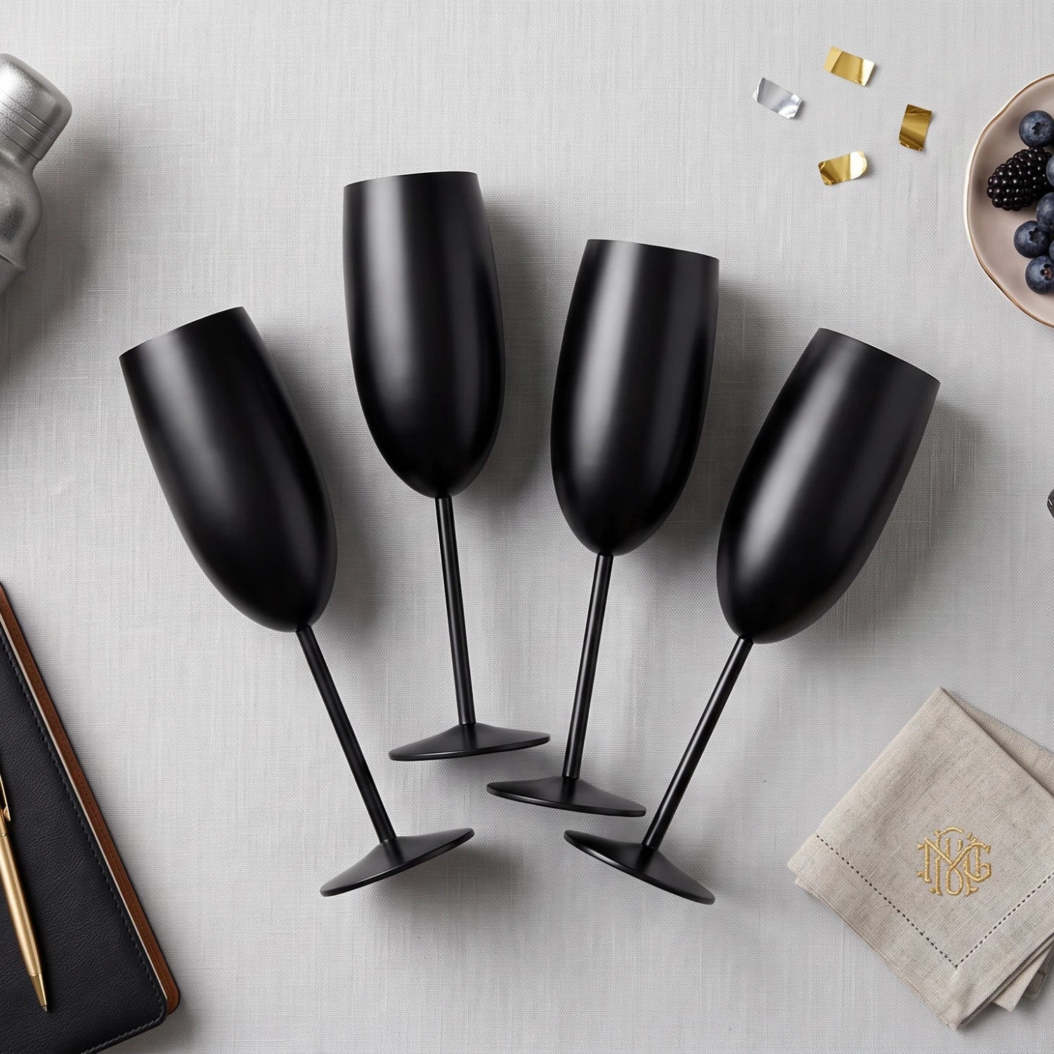 Four matte black champagne flutes with long stems and round bases