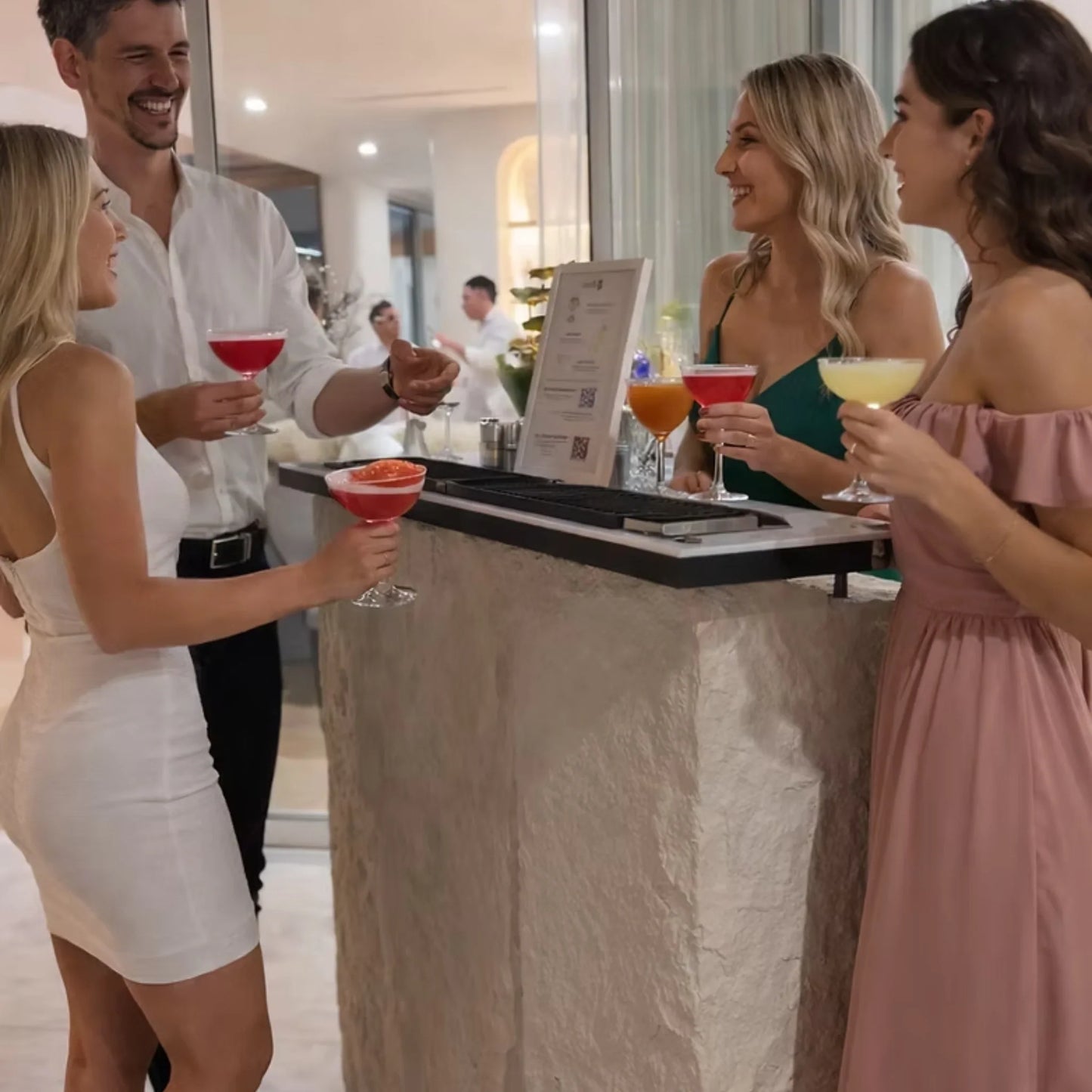 Guests holding cocktails and gathering around the On The Bars Premium Mobile Bar at an indoor event.