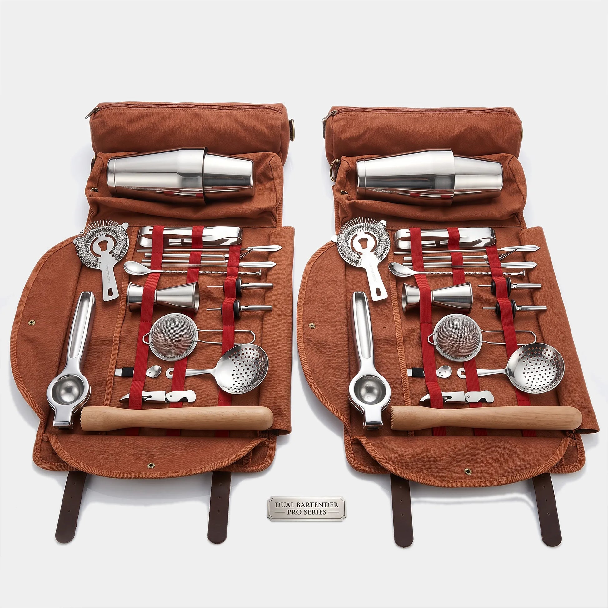 Two matching brown canvas roll-up tool cases opened side by side, each holding a stainless steel cocktail bartender set with wooden-handled tools, strainers, muddler, ice bucket, and metal cups. A small plaque at the bottom reads 'COCKTAIL BARTENDER SET V.
