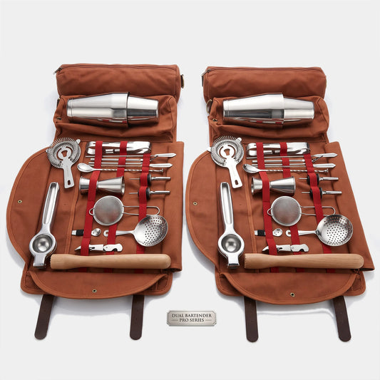 Two matching brown canvas roll-up tool cases opened side by side, each holding a stainless steel cocktail bartender set with wooden-handled tools, strainers, muddler, ice bucket, and metal cups. A small plaque at the bottom reads 'COCKTAIL BARTENDER SET V.