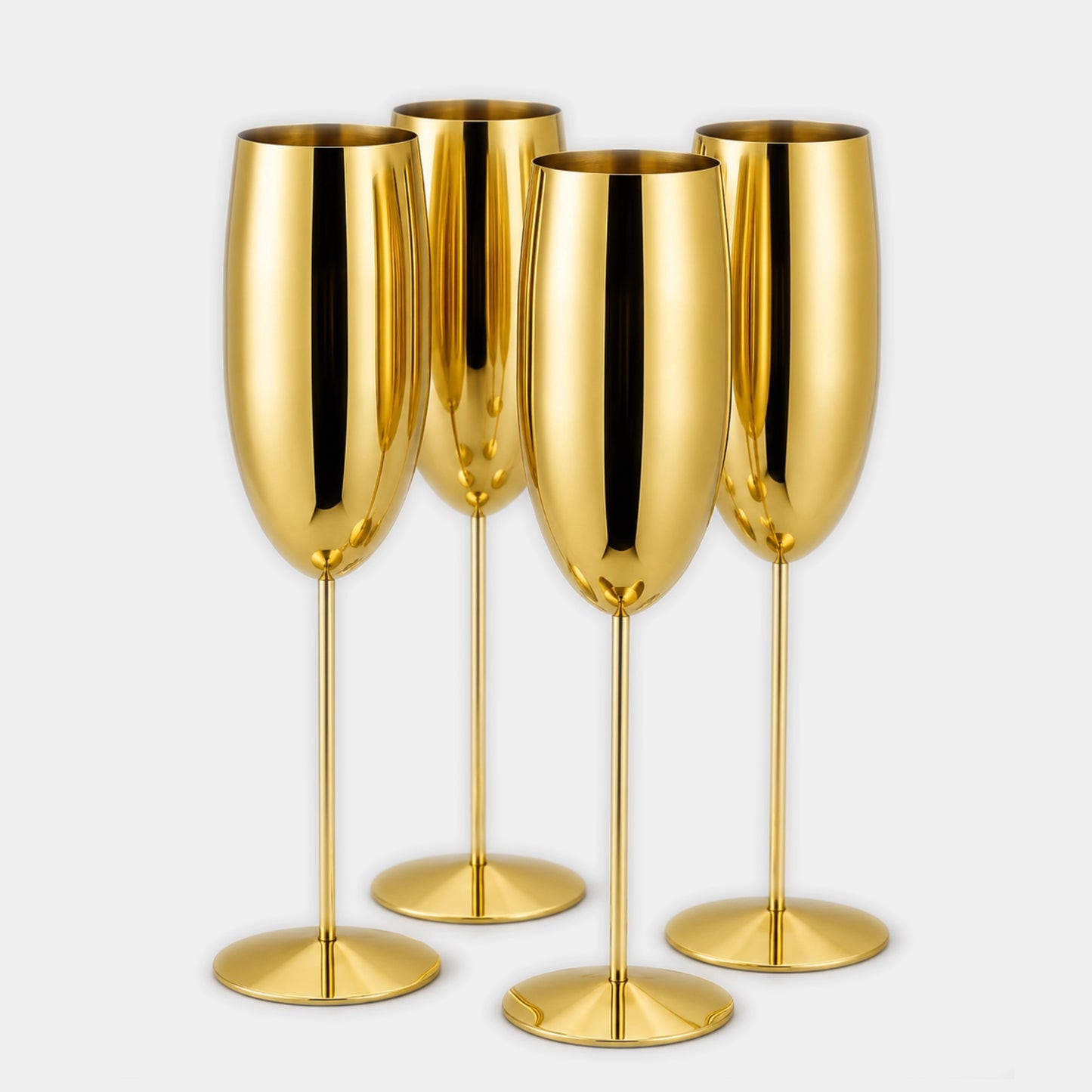 Four shiny gold champagne flutes arranged together on a light gray background.